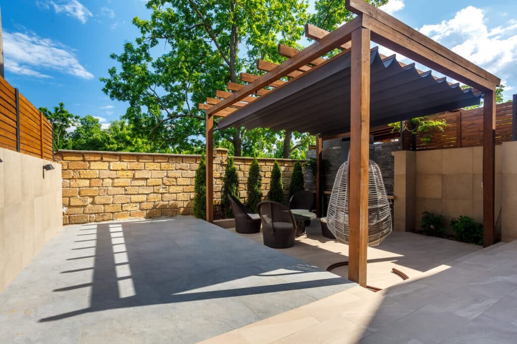 Backyard outdoor bbq zone with wooden pergola.